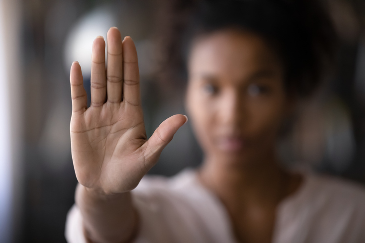 A woman raises her hand to form a stop gesture